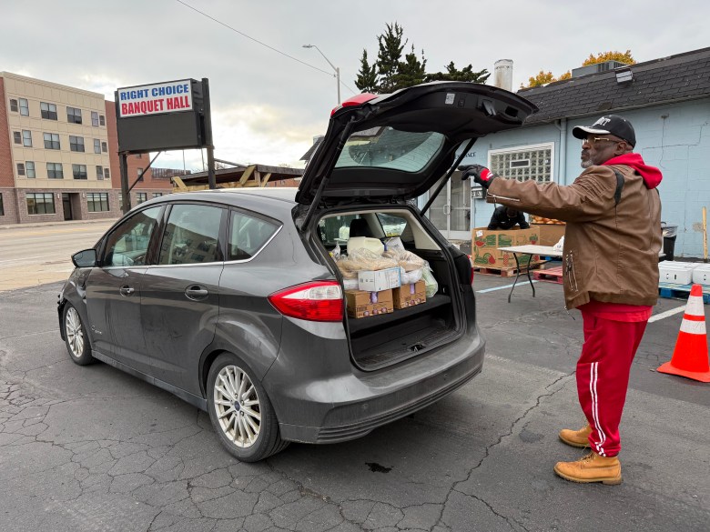 Carl Brown loads up his car in a parking lot.