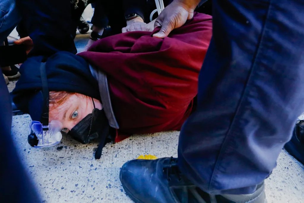 NYPD officers arrest a person on the pavement after protesters tried to block federal agents from leaving a garage near Canal Street.