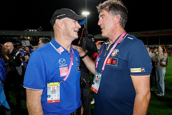 Brisbane coach Craig Starcevich, right, congratulates North Melbourne coach Darren Crocker on Saturday night.