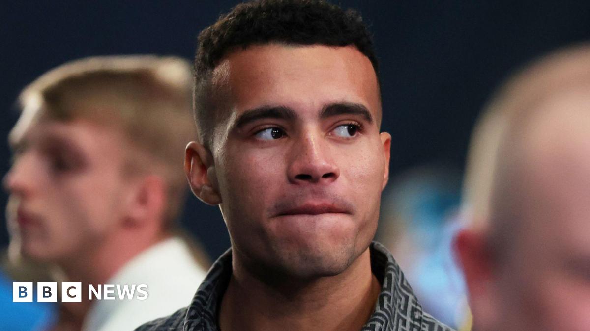 A man with short black hair looking away from the camera.