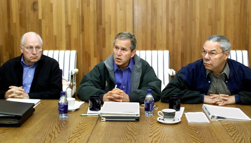 Cheney sits next to President George W. Bush as he meets with his cabinet and advisers, including Secretary of State Colin Powell, on September 15, 2001, at Camp David in Maryland.