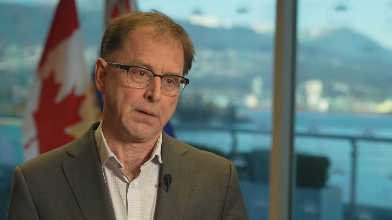 A man in a suit looks at the camera during an interview. 
