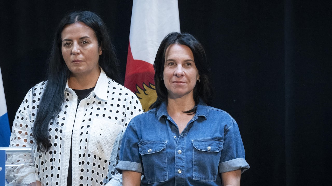 Two people standing next to one another. 