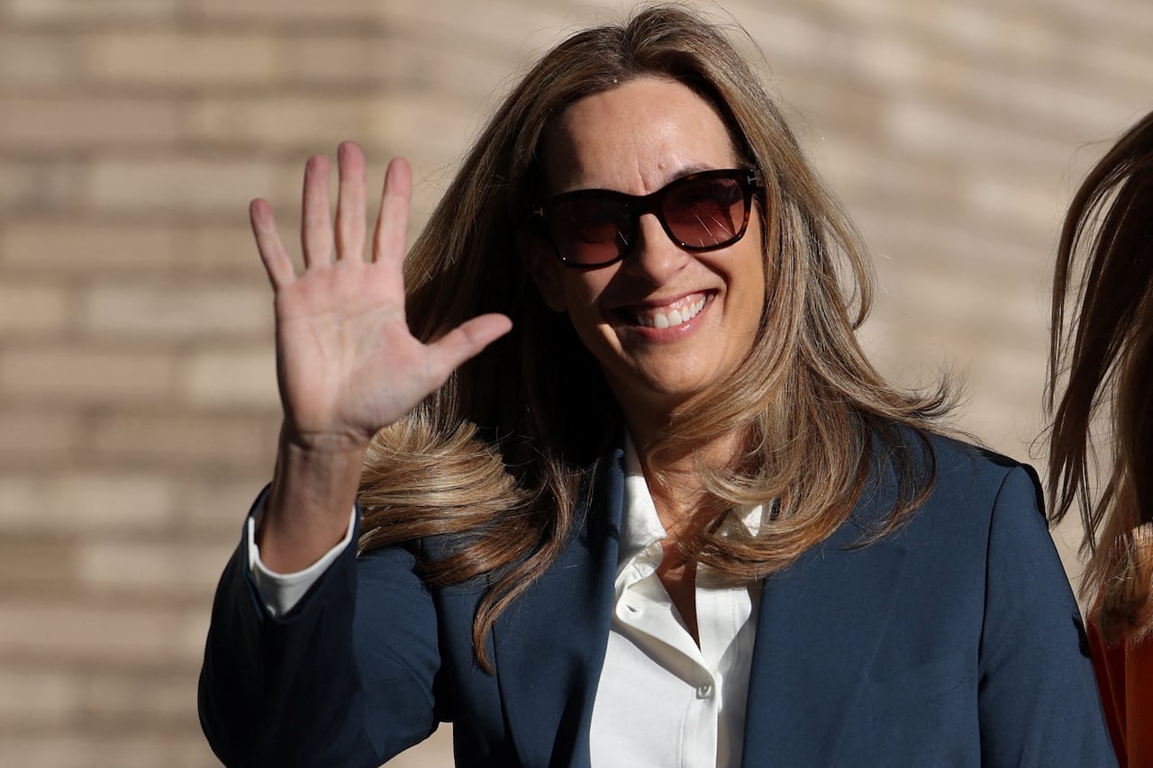A woman, who is wearing sunglasses, is seen waving