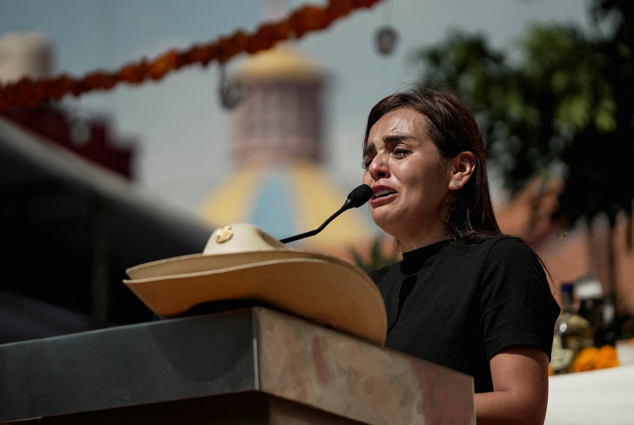 A woman who appears to be anguished is shown speaking at a podium.