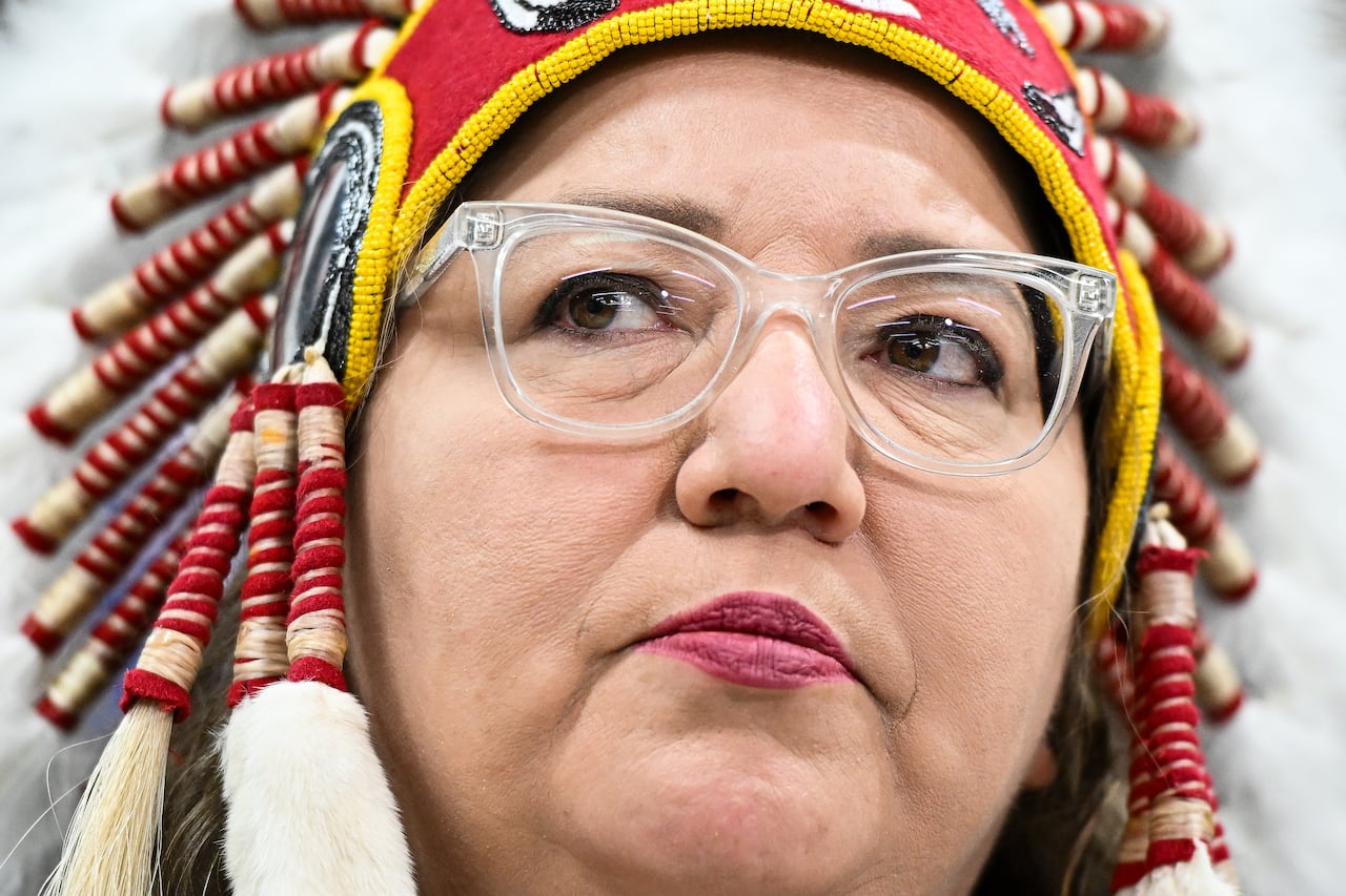 National chief in a headdress is seen in a close up picture.