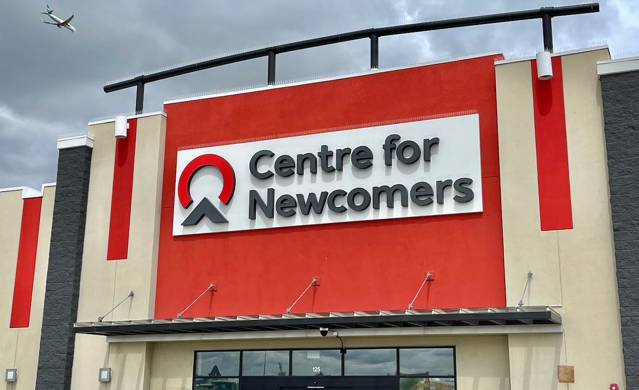 A building with a red sign that reads centre for newcomers.