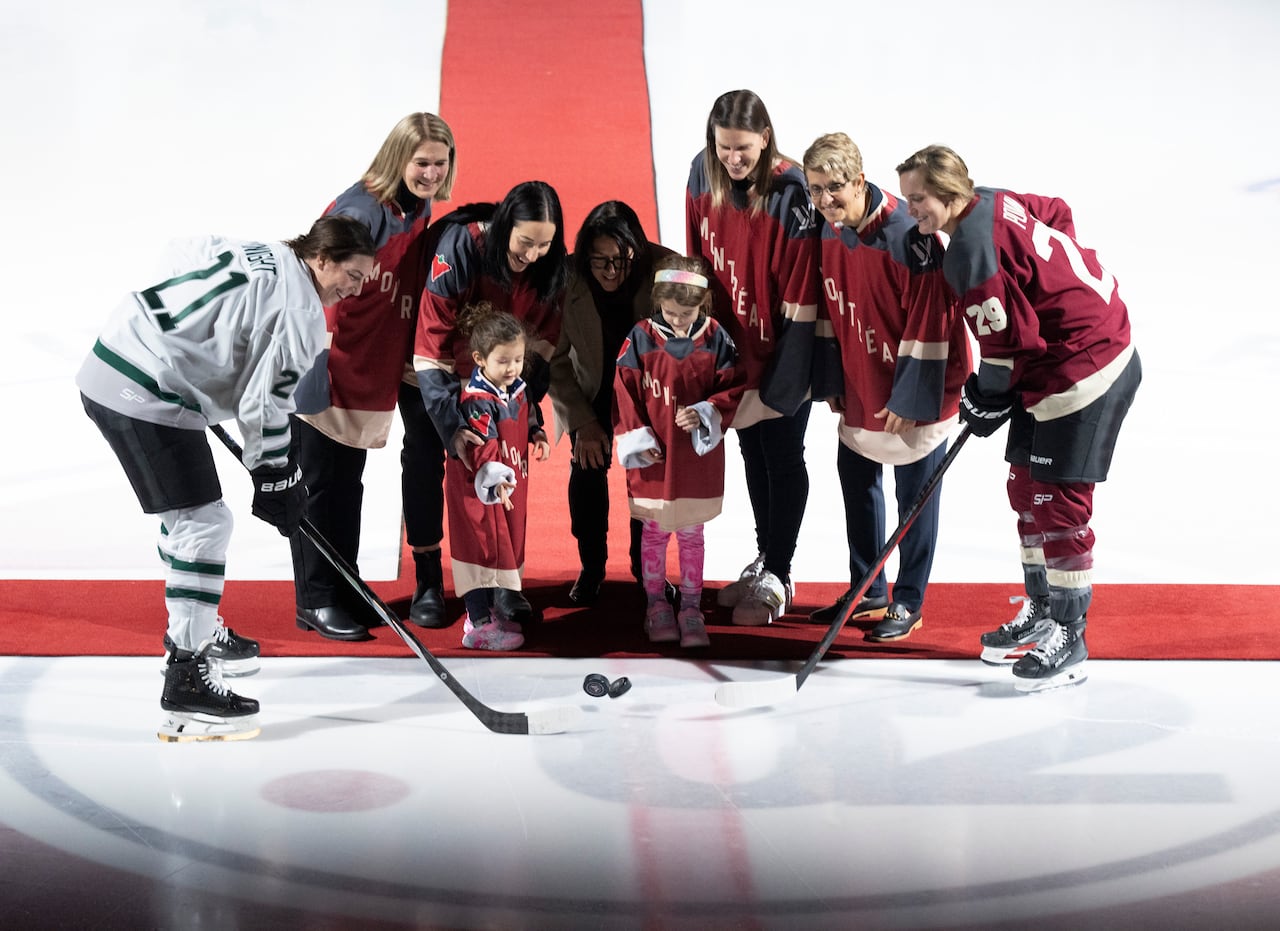 Players, coaches and former Olympians pose for the first ceremonial puck drop in PWHL Montreal history.