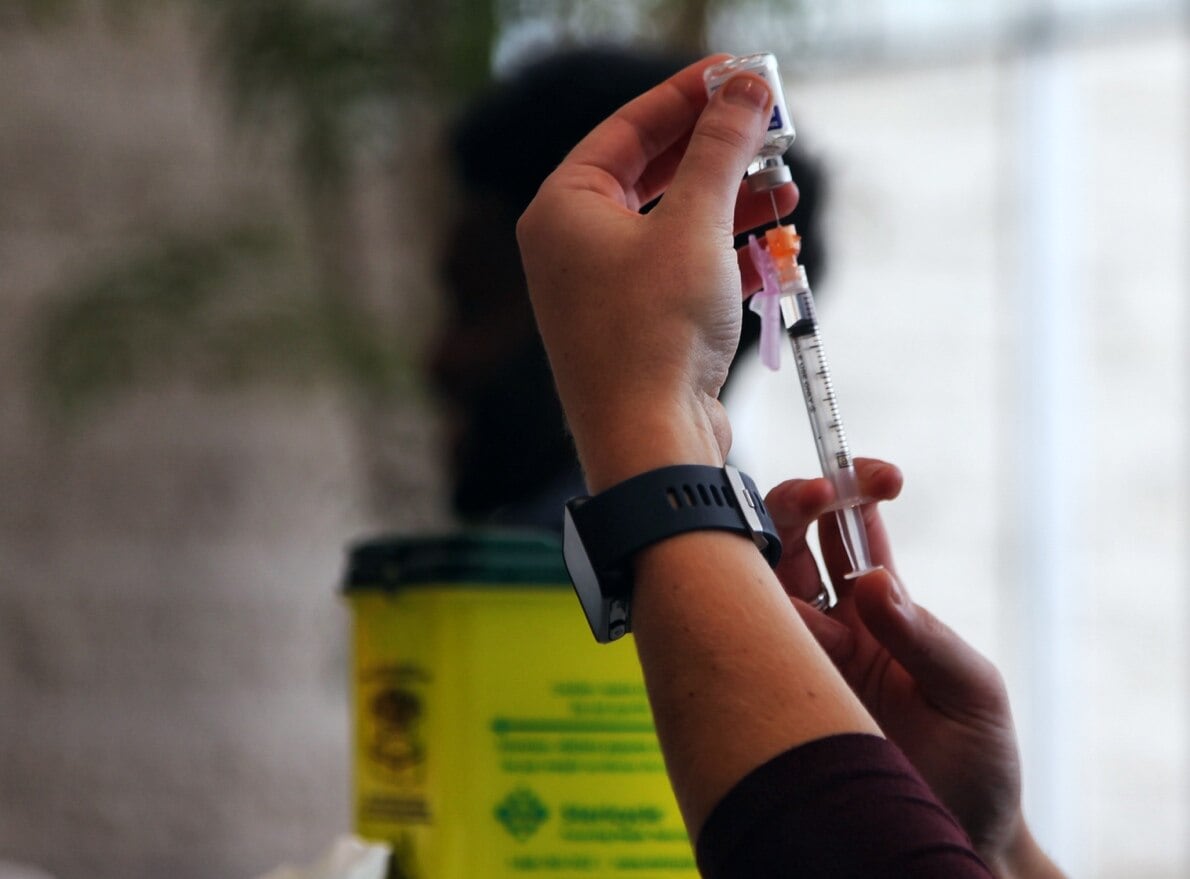 Hands holding a syringe of the flu vaccine