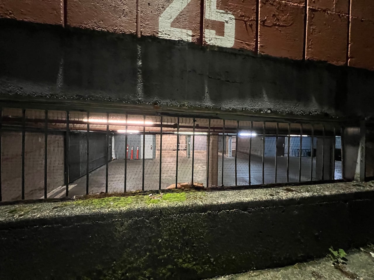 through a window, you can see an underground parking garage with no cars in it