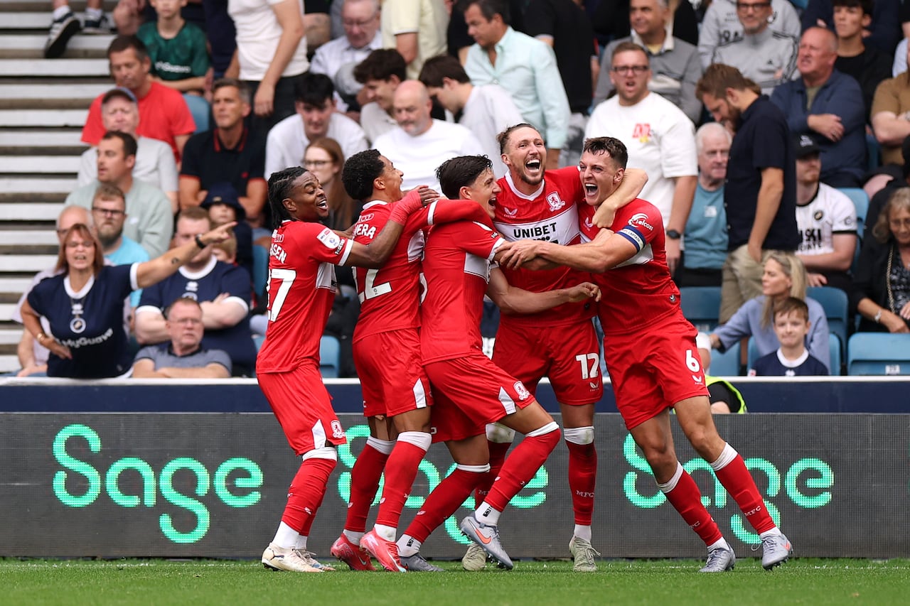 Soccer players celebrate a goal.
