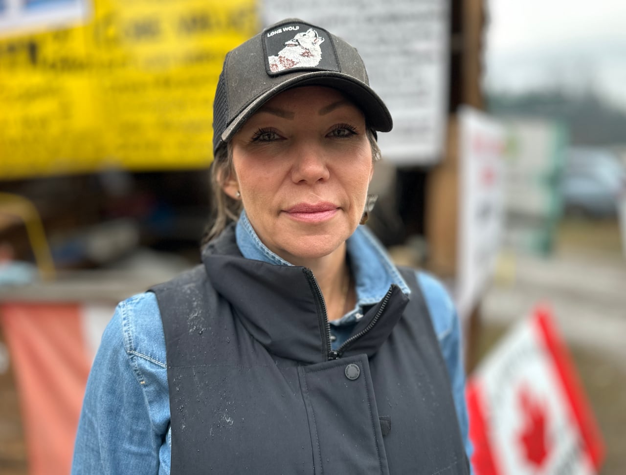 A woman wearing a baseball cap poses for a photo. 