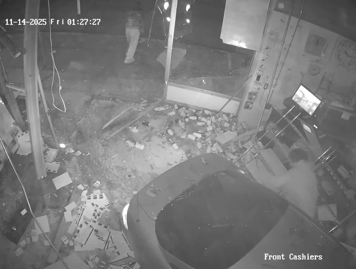 black and white video frame showing two people leaving crash