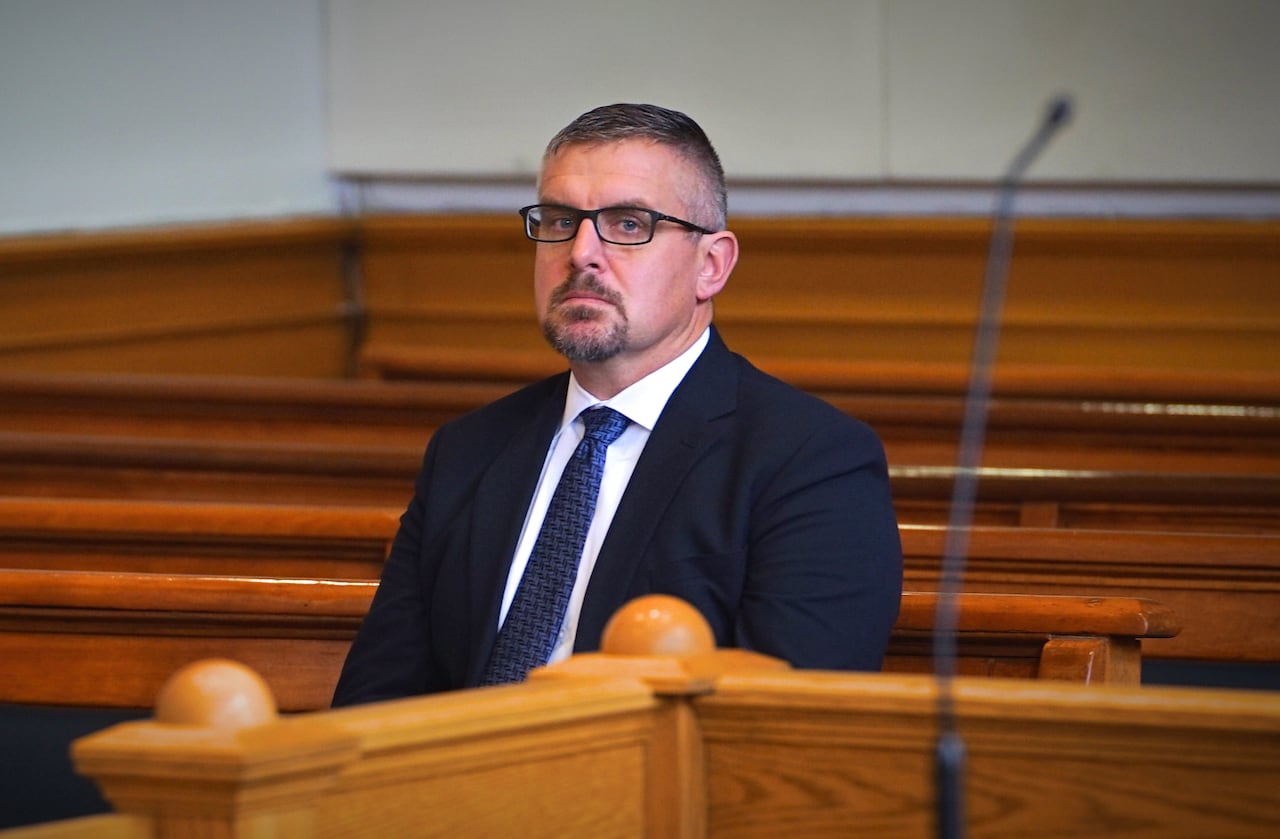 A man sitting on a court bench.