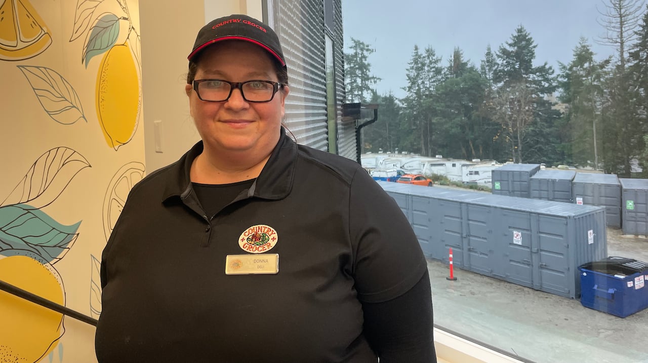 a woman stands in a grocery store uniform