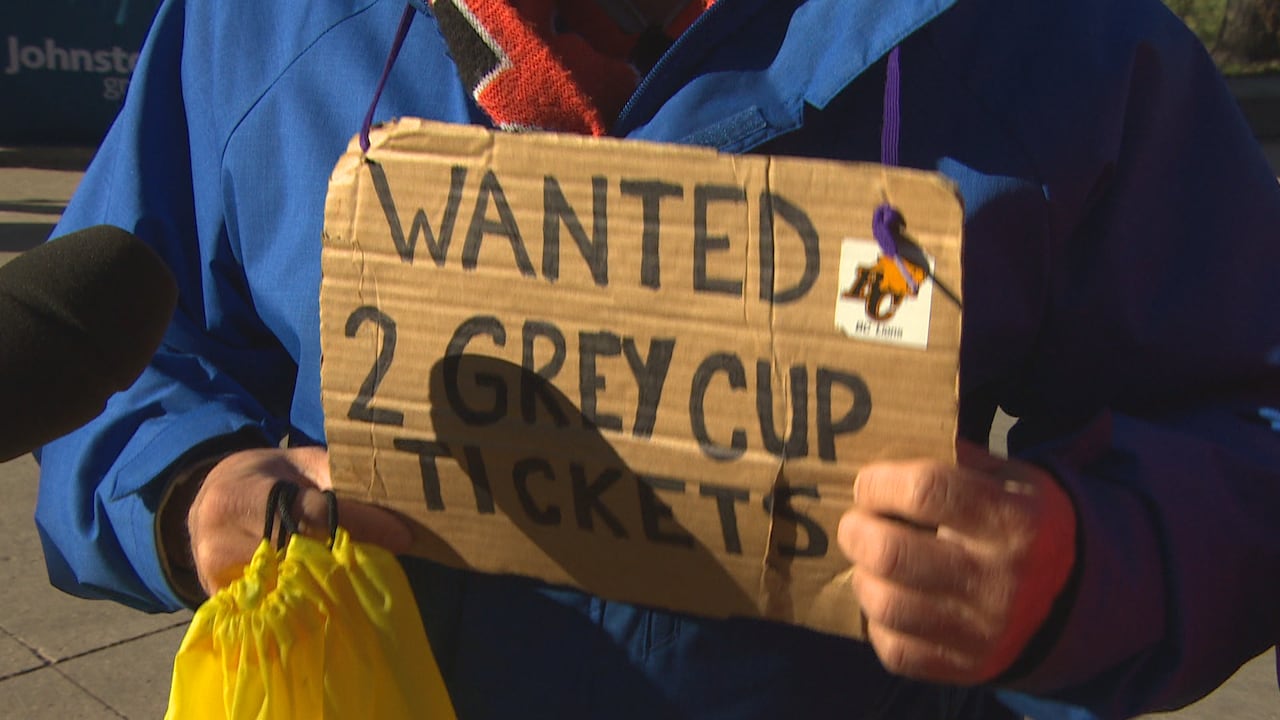 A cardboard sign says wanted to Grey Cup tickets