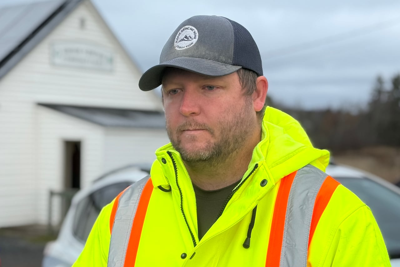 A man in a yellow safety jacket and a ball cap.