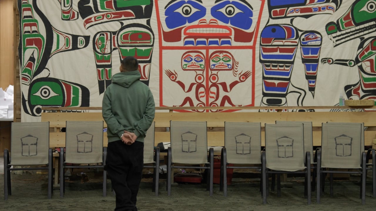 Man stands in a Heiltsuk big house.
