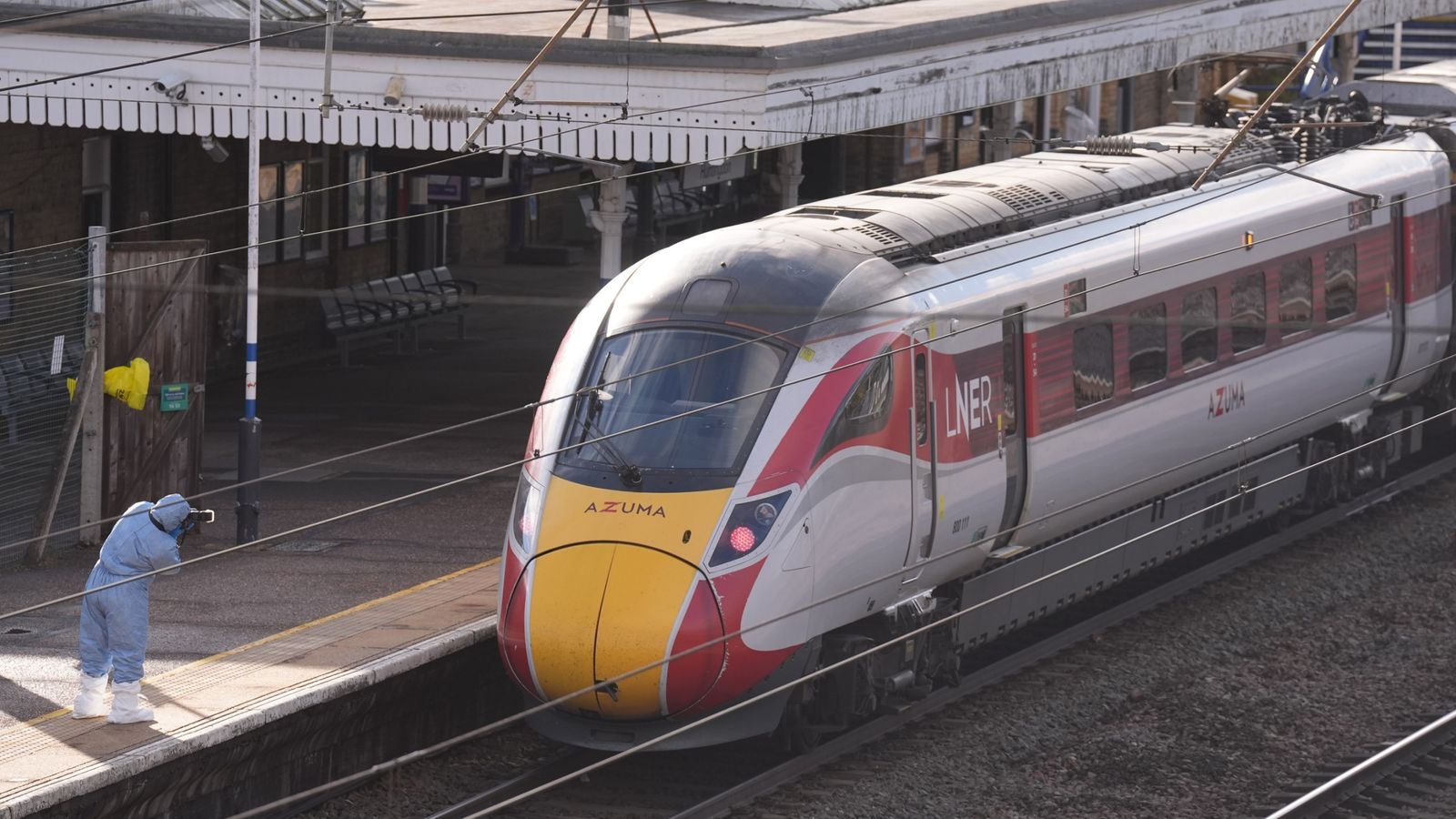 A forensic investigator on the platform by the train at Huntingdon train station in Cambridgeshire