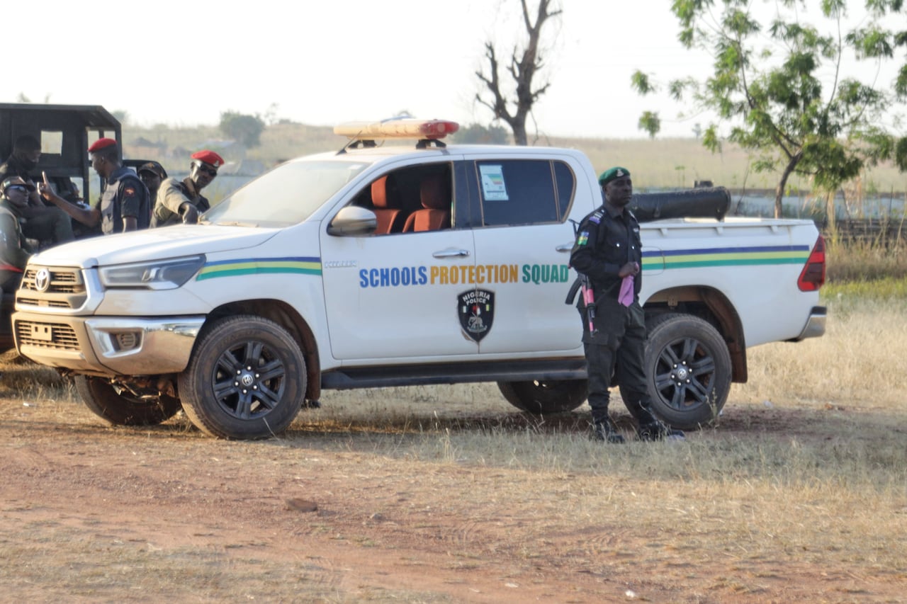 Police officers stand guard outside of a school. 