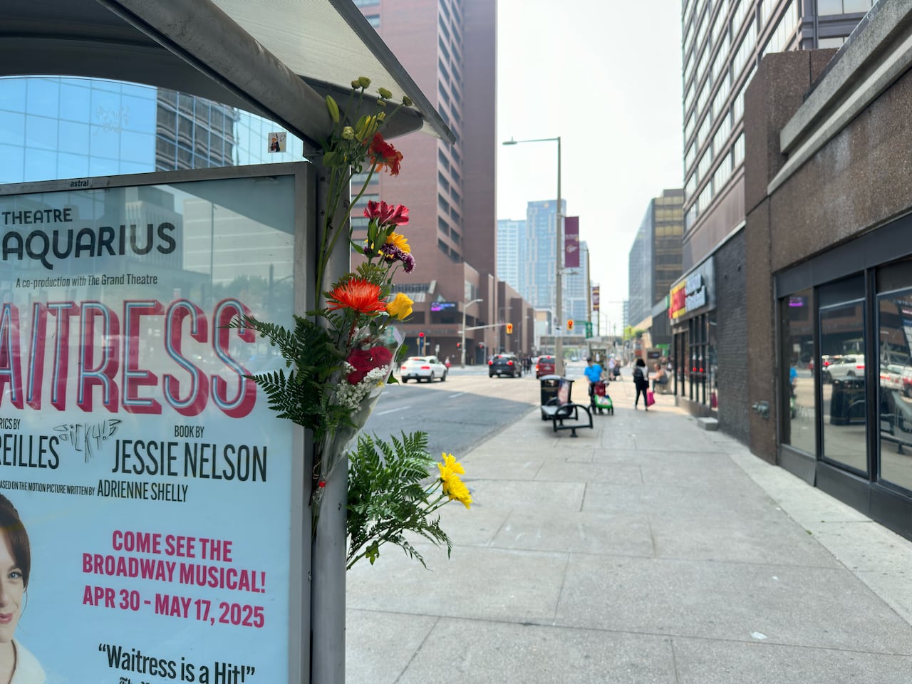 Flowers taped to the side of a bus shelter