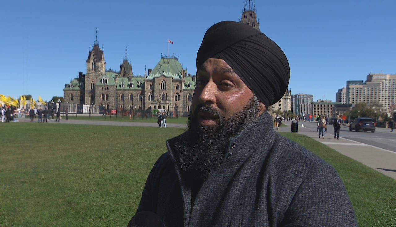 A man with a beard and turban standing on Parliament Hill.