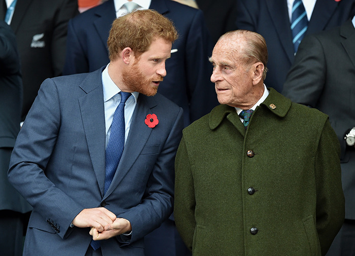 Prince Philip talking to Prince Harry at a public event, highlighting warnings before his Meghan Markle wedding.
