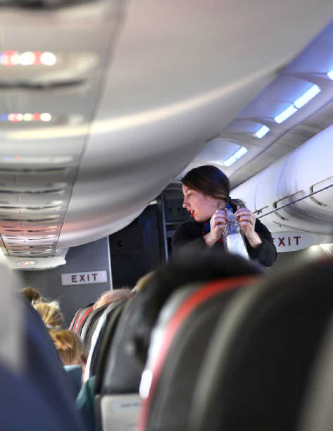 An American Airlines flight attendant serves drinks to passengers after departing Dallas/Fort Worth International Airport.