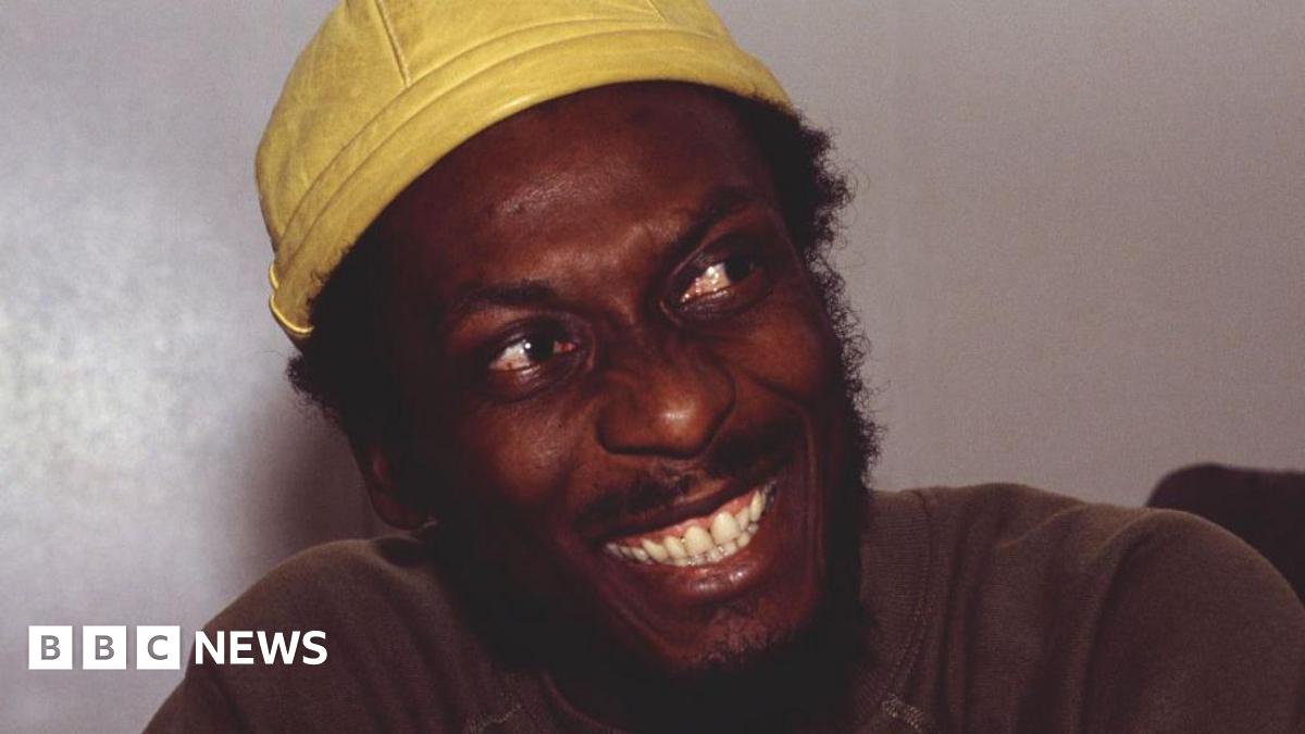 Jimmy Cliff smiling with a yellow cap on
