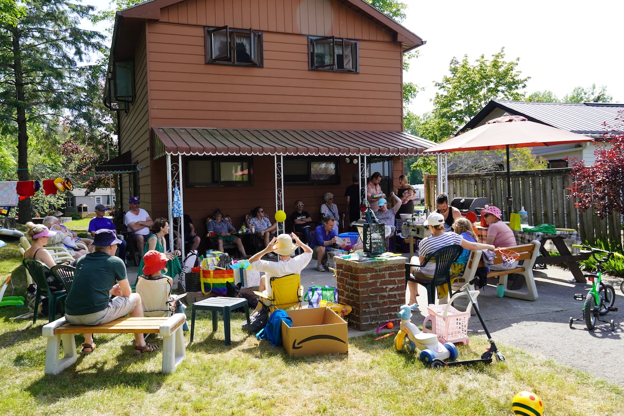 A two-story cottage with brown siding on a river.