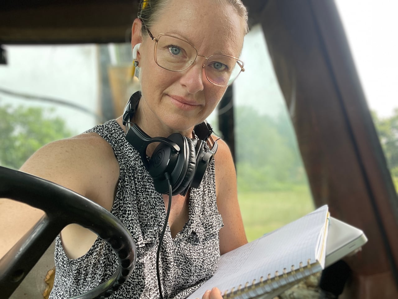 A white woman in a tractor smiling in a selfie-style photo.