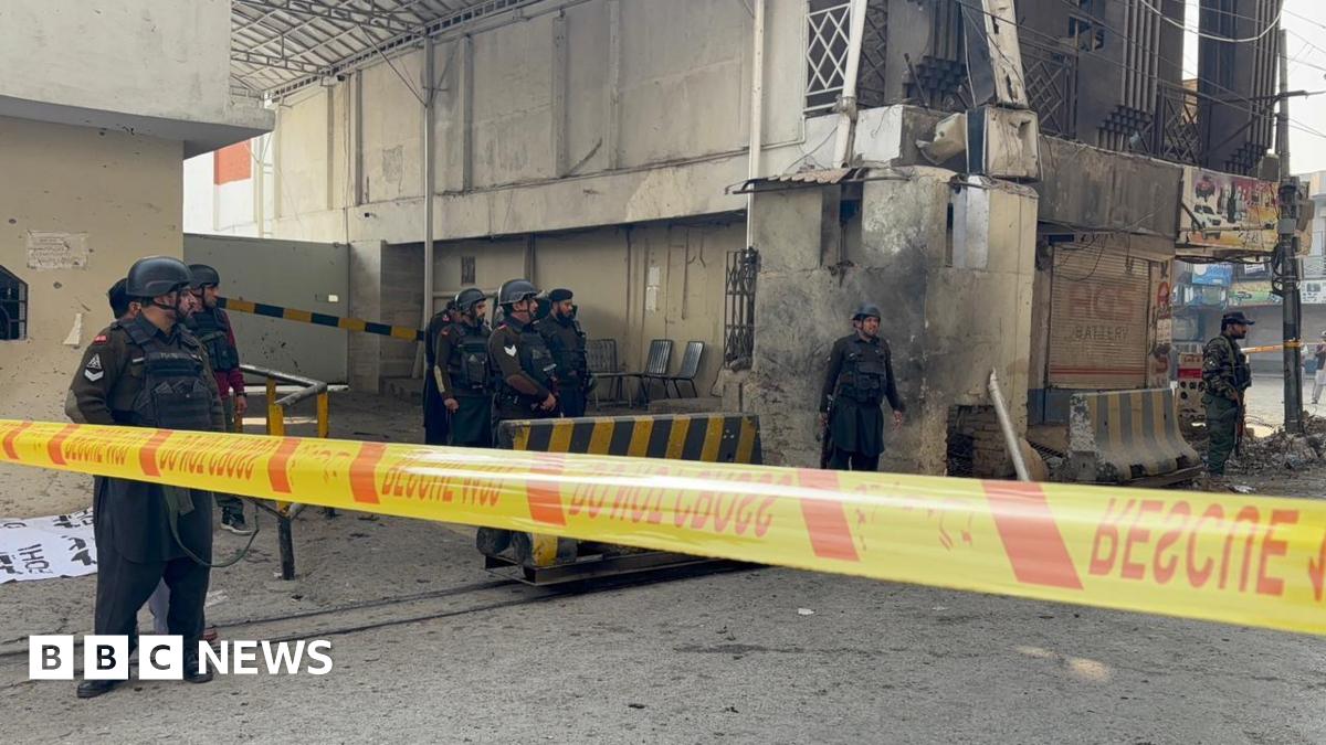 Part of the Federal Constabulary headquarters in Peshawar cordoned off with yellow tape after a suicide bomb attack. Security officers armed with guns are seen on site