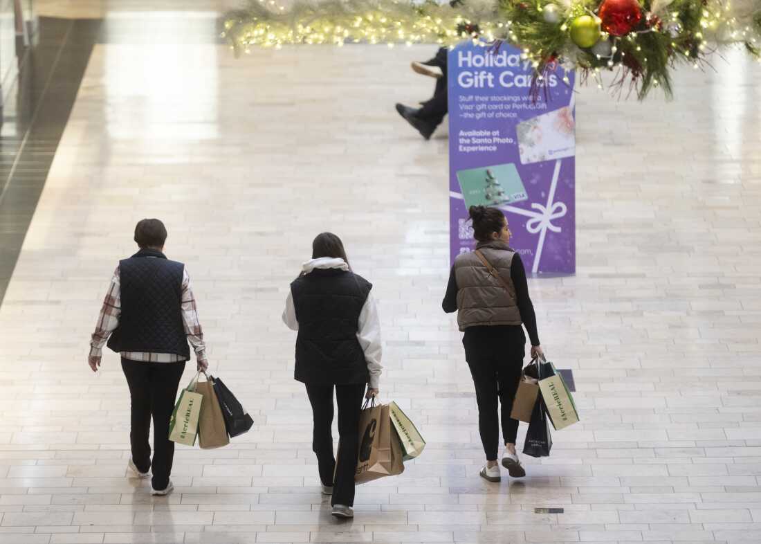 Shoppers walk around Ross Park Mall near Pittsburgh earlier this month. For the first time, it says, Americans will spend more than $1 trillion on gifts, food and decorations.