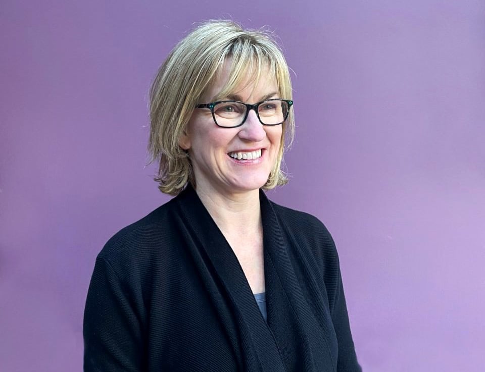 A woman in glasses and a sweater.