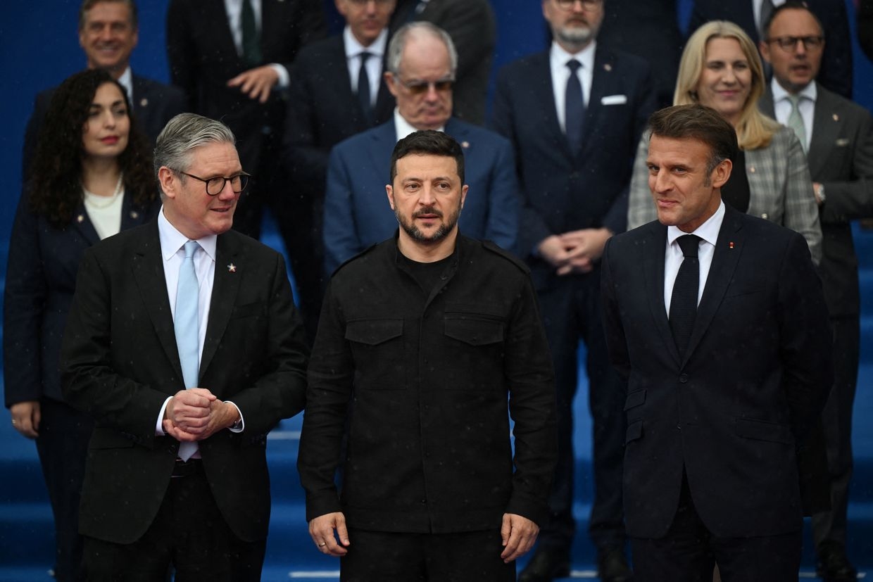 President Volodymyr Zelensky (C) stands between French President Emmanuel Macron (R) and U.K. Prime Minister Keir Starmer (L)