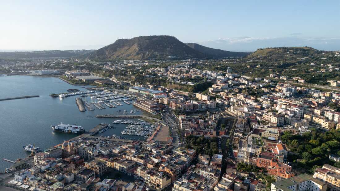 Aerial view of the densely inhabited area of Pozzuoli, located within the Campi Flegrei volcanic caldera. Over half a million people live in this region, which is continuously monitored due to the ongoing volcanic activity and the risk of ground uplift, earthquakes, and gas emissions associated with bradyseism