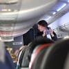 An American Airlines flight attendant serves drinks to passengers after departing Dallas/Fort Worth International Airport.