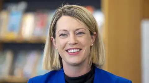 PA Media Jenny Gilruth with blonde hair and a blue suit jacket head and shoulders shot