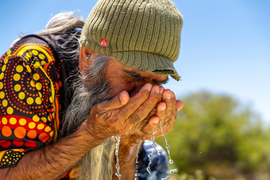 Arabana elder Joe Hull cupping water.