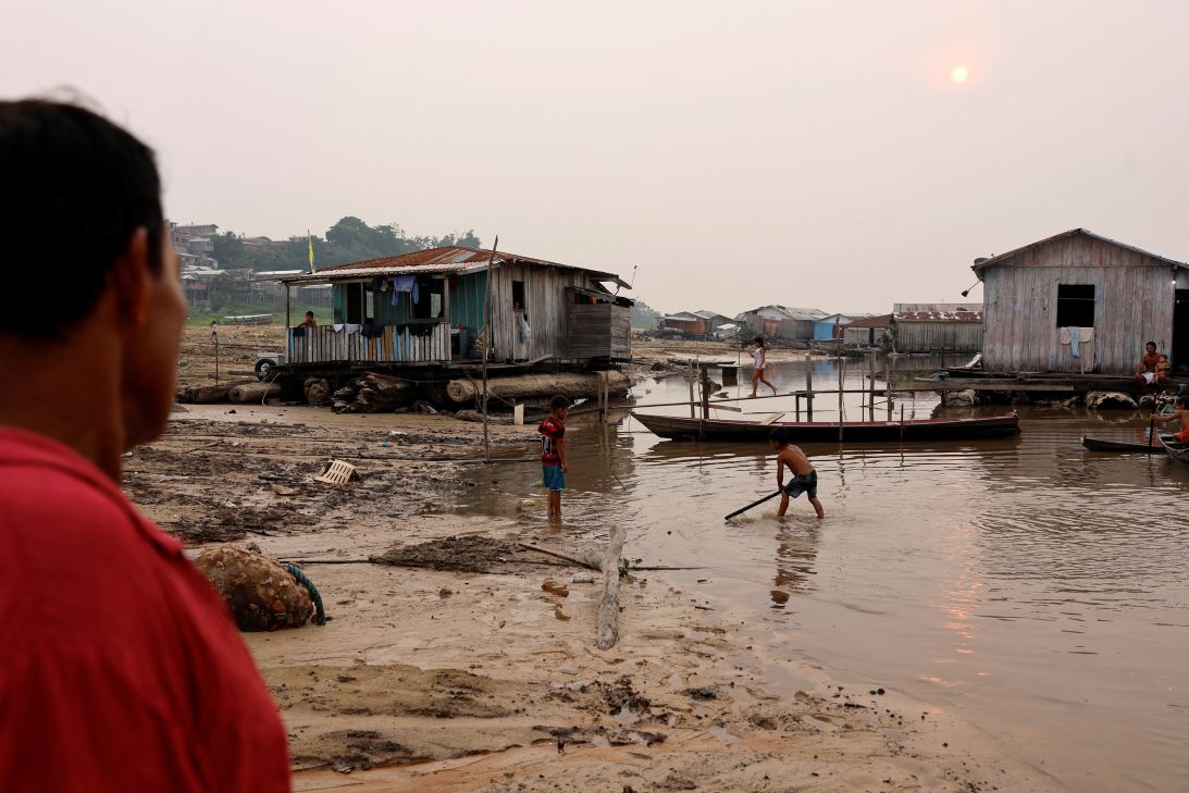 Children play next to floating houses on the dry banks of Lake Tefé on September 17, 2024, during the most intense and widespread drought Brazil has experienced since records began in 1950.