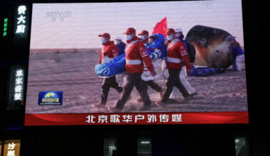 Giant screen shows news footage of astronaut of Shenzhou-20 mission outside the return capsule of the Shenzhou-21 spacecraft