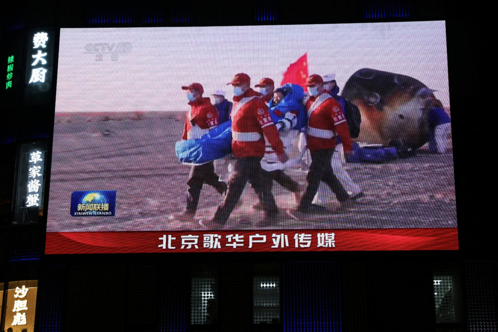 Giant screen shows news footage of astronaut of Shenzhou-20 mission outside the return capsule of the Shenzhou-21 spacecraft