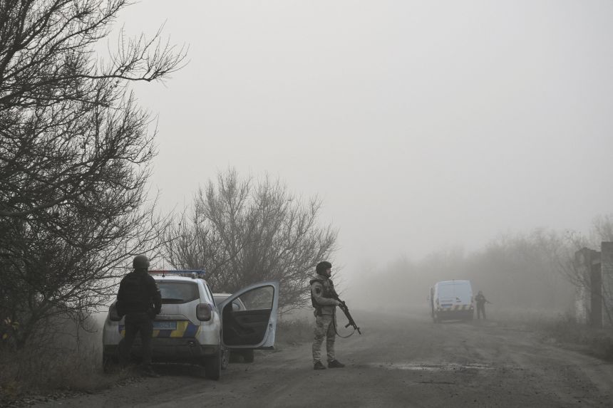 Ukrainian police officers observe an area on their way to evacuate civilians from the frontline town of Huliaipole, in Ukraine's Zaporizhzhia region, on November 14, 2025.