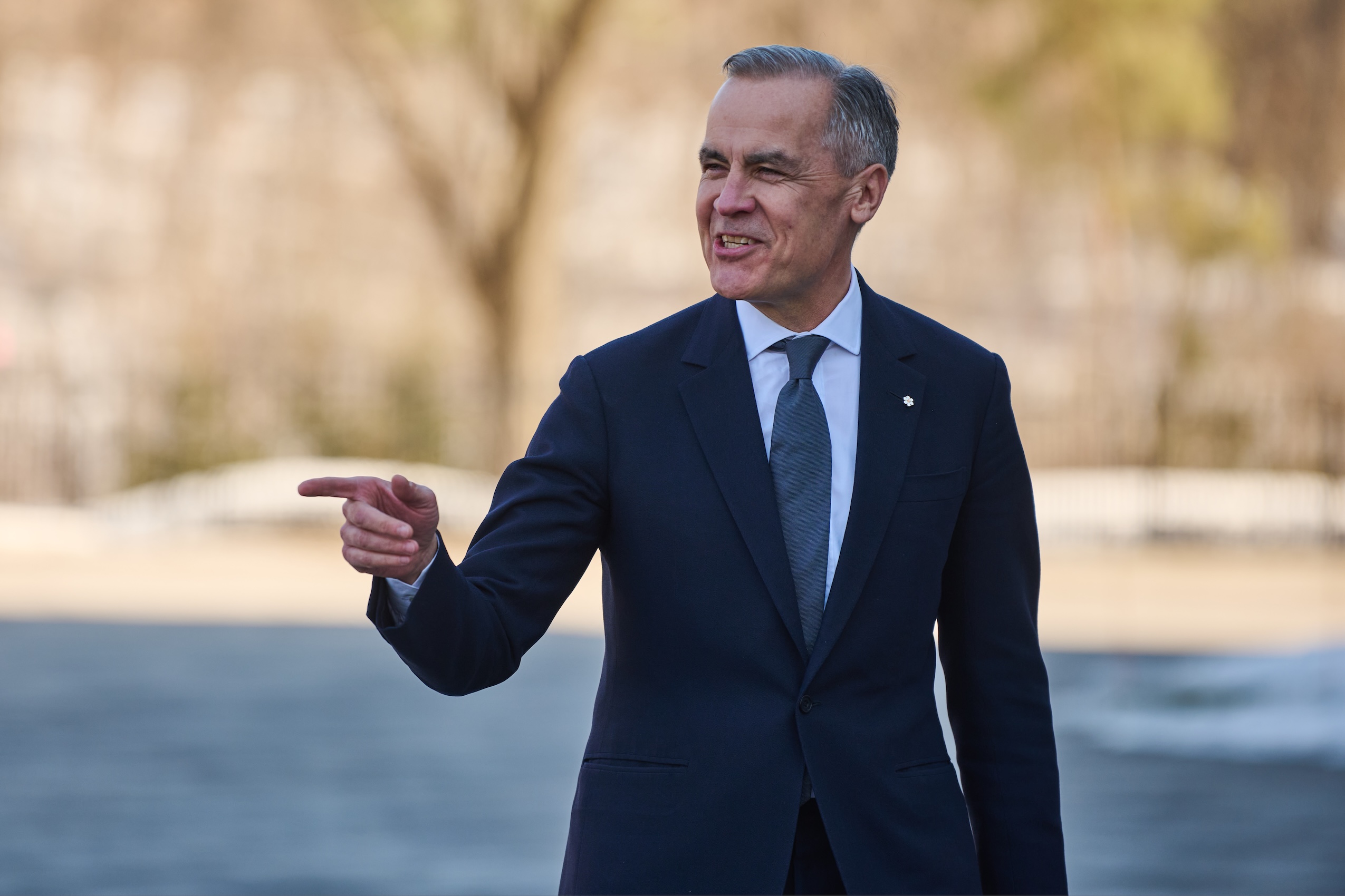 Mark Carney pointing towards a crowd and smiling.
