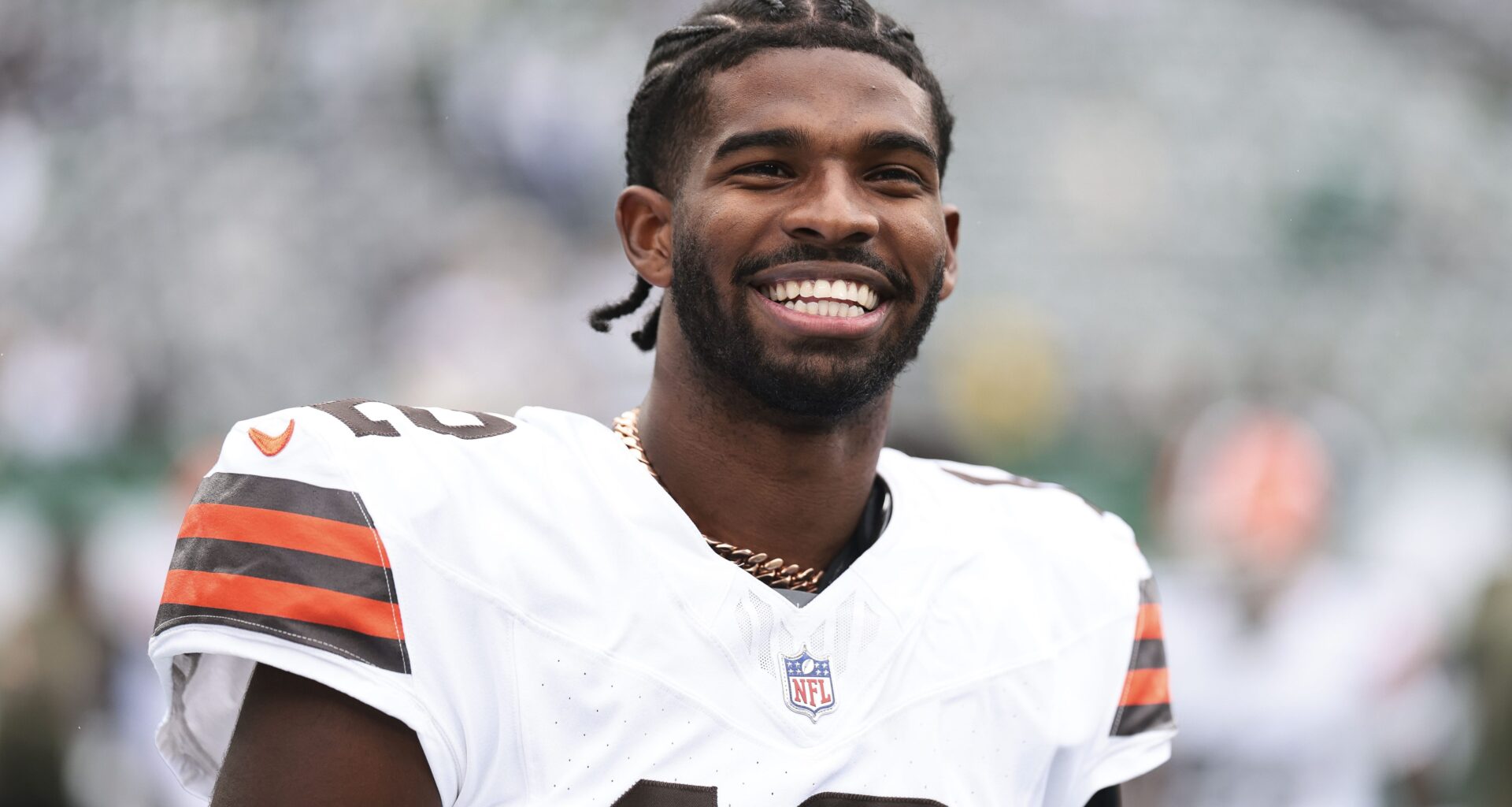 Shedeur Sanders smiles on the field prior to the game