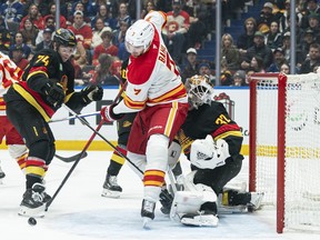 Kevin Bahl #7 of the Calgary Flames runs into goalie Kevin Lankinen of the Vancouver Canucks as he skates through the crease during the first period at Rogers Arena on Sunday night.