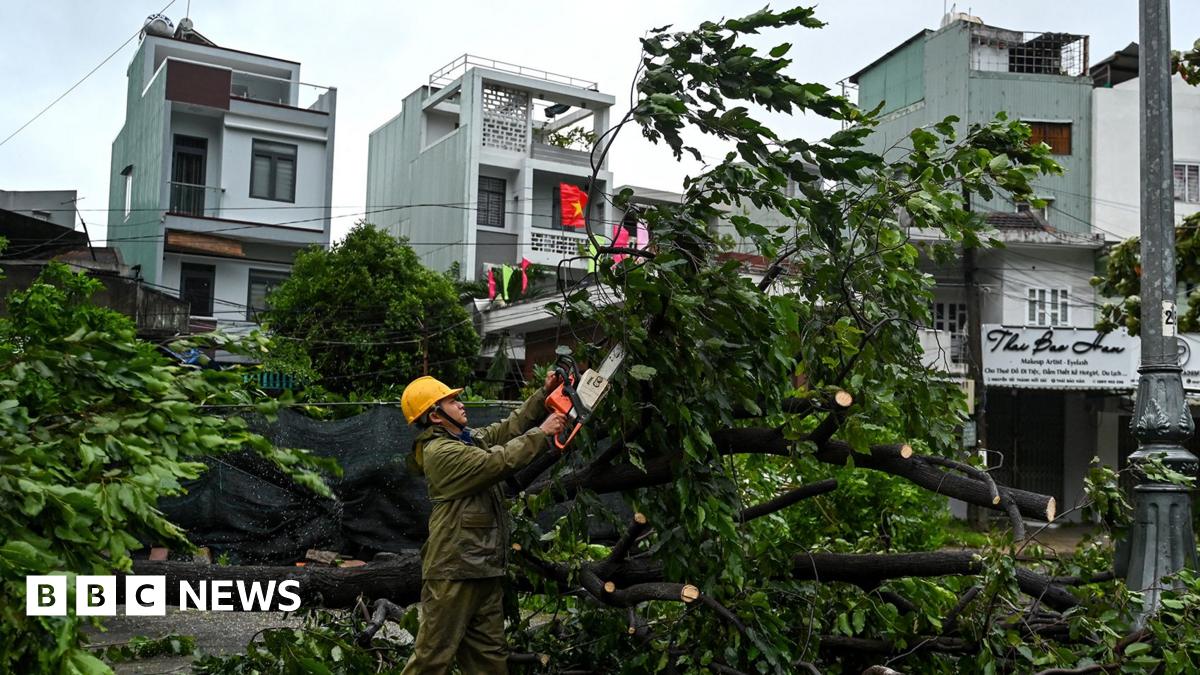 Cars are lumped together in two piles in a flooded street in the Philippines.