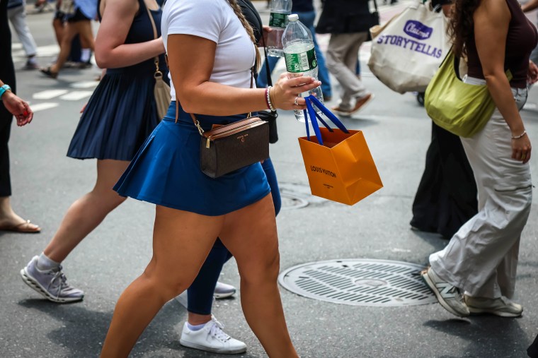 A shopper carries a Louis Vuitton store bag