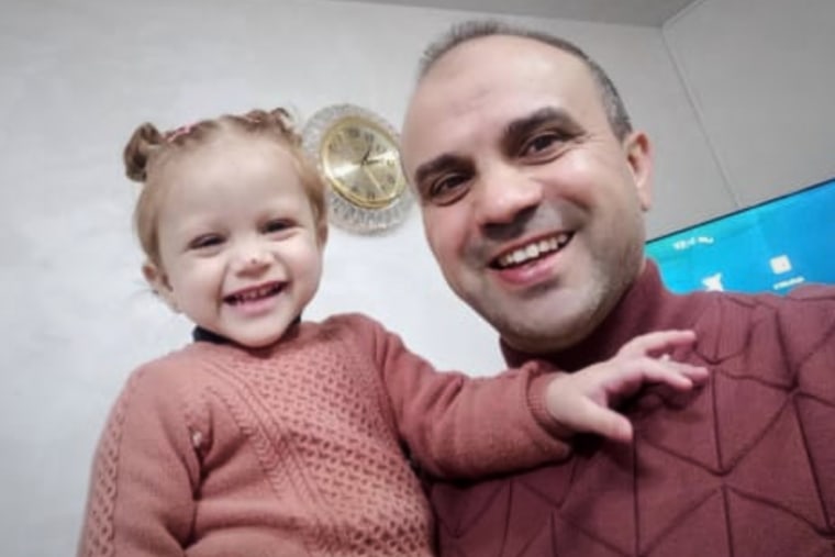 Mohammad Husein Ali holds his toddler daughter