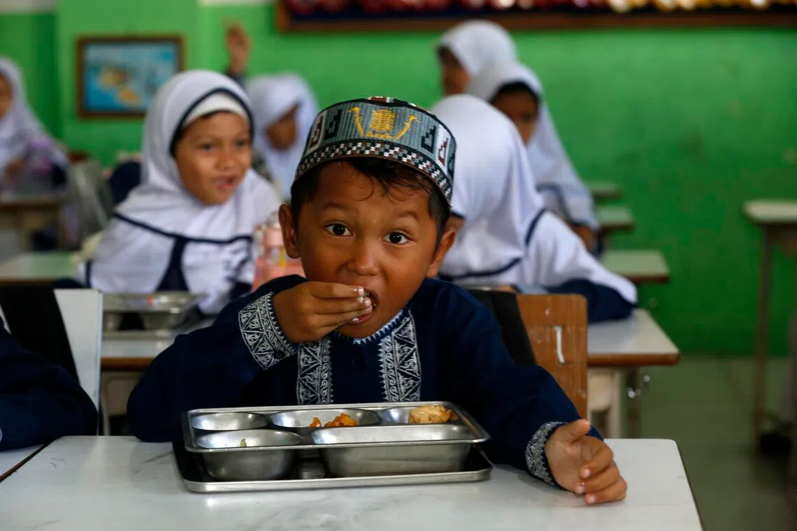 An Indonesian student eats a free meal at an elementary school in Banda Aceh, Indonesia, on Oct 30.